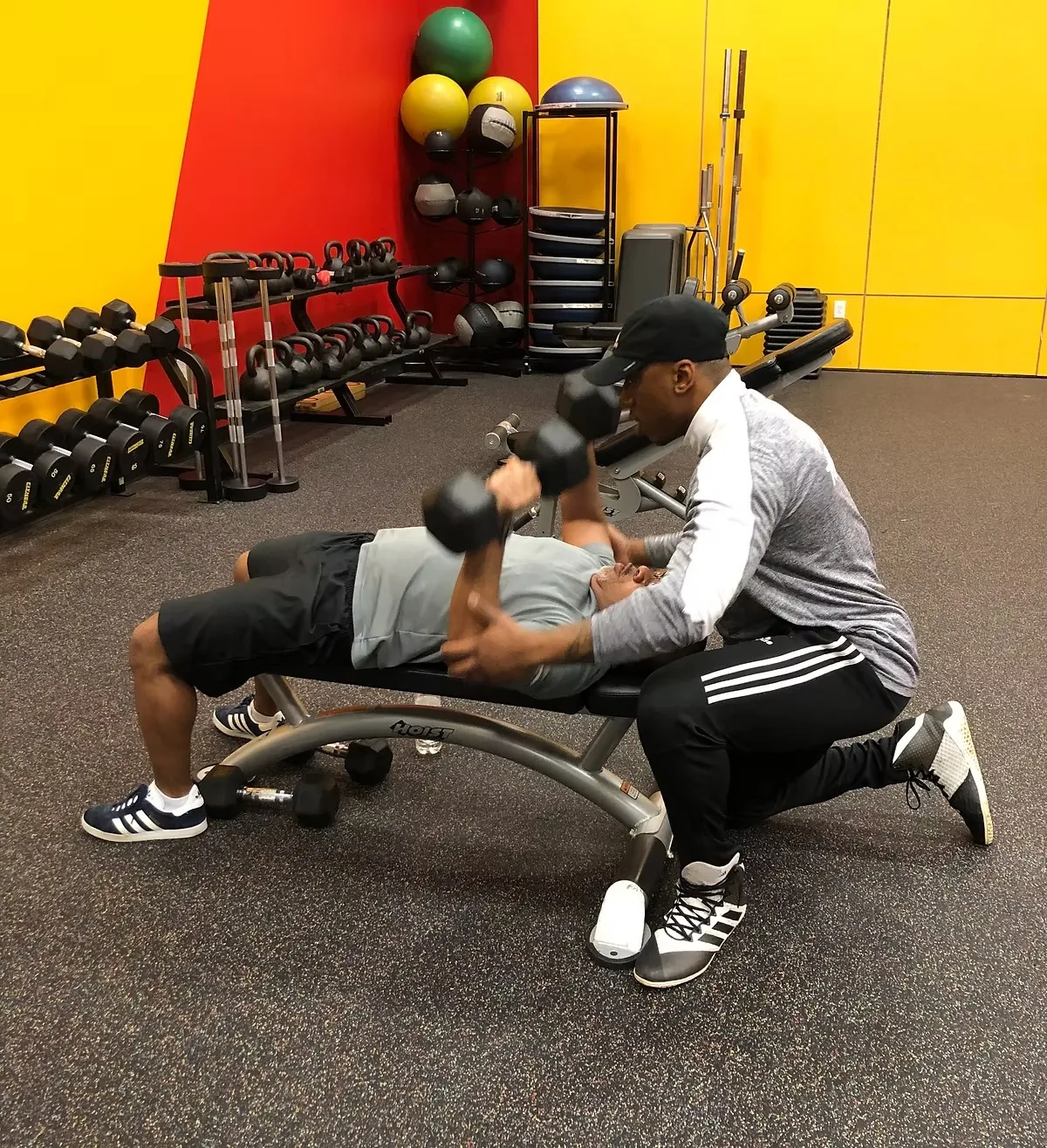 Coach spotting a member on the bench press