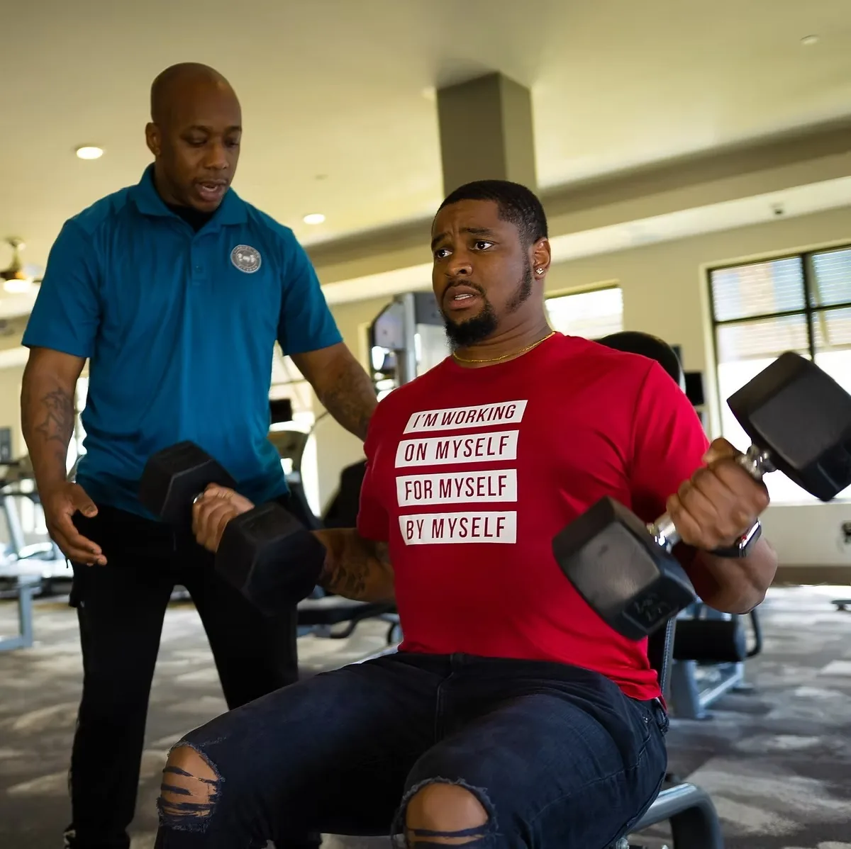 Coach guiding a member through a dumbbell press